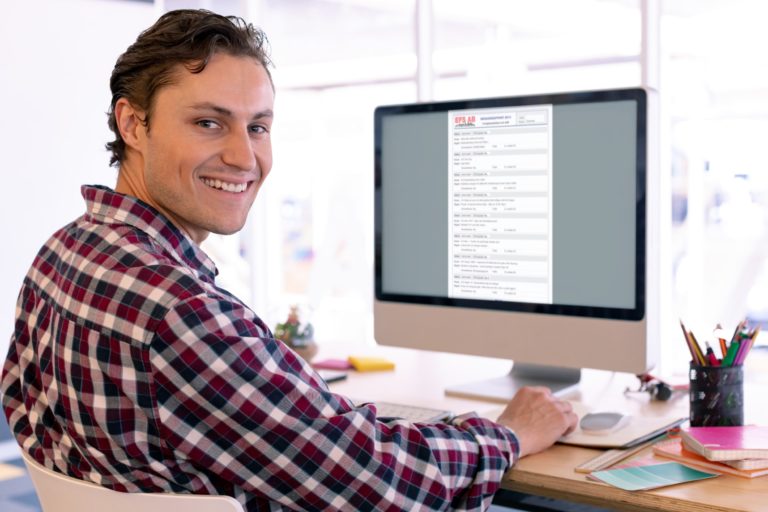 En man sitter vid en datorskärm med rapportblad och EFS AB logo längst upp